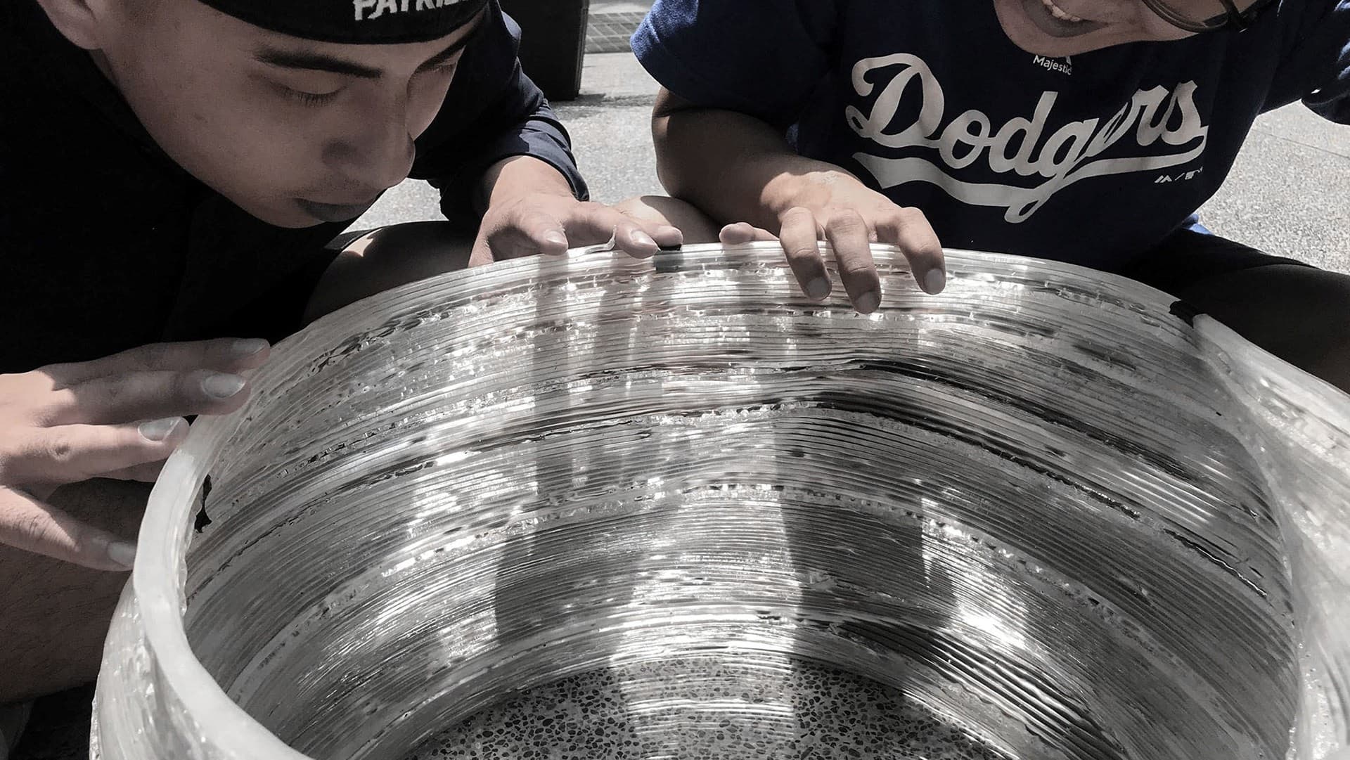 Team inspecting the layered transparent PLA surface.
